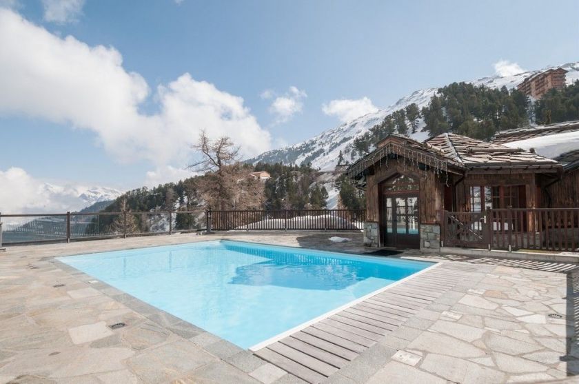 La piscine extérieure du bâtiment Le Manoir de Savoie, dans la Résidence Le Village